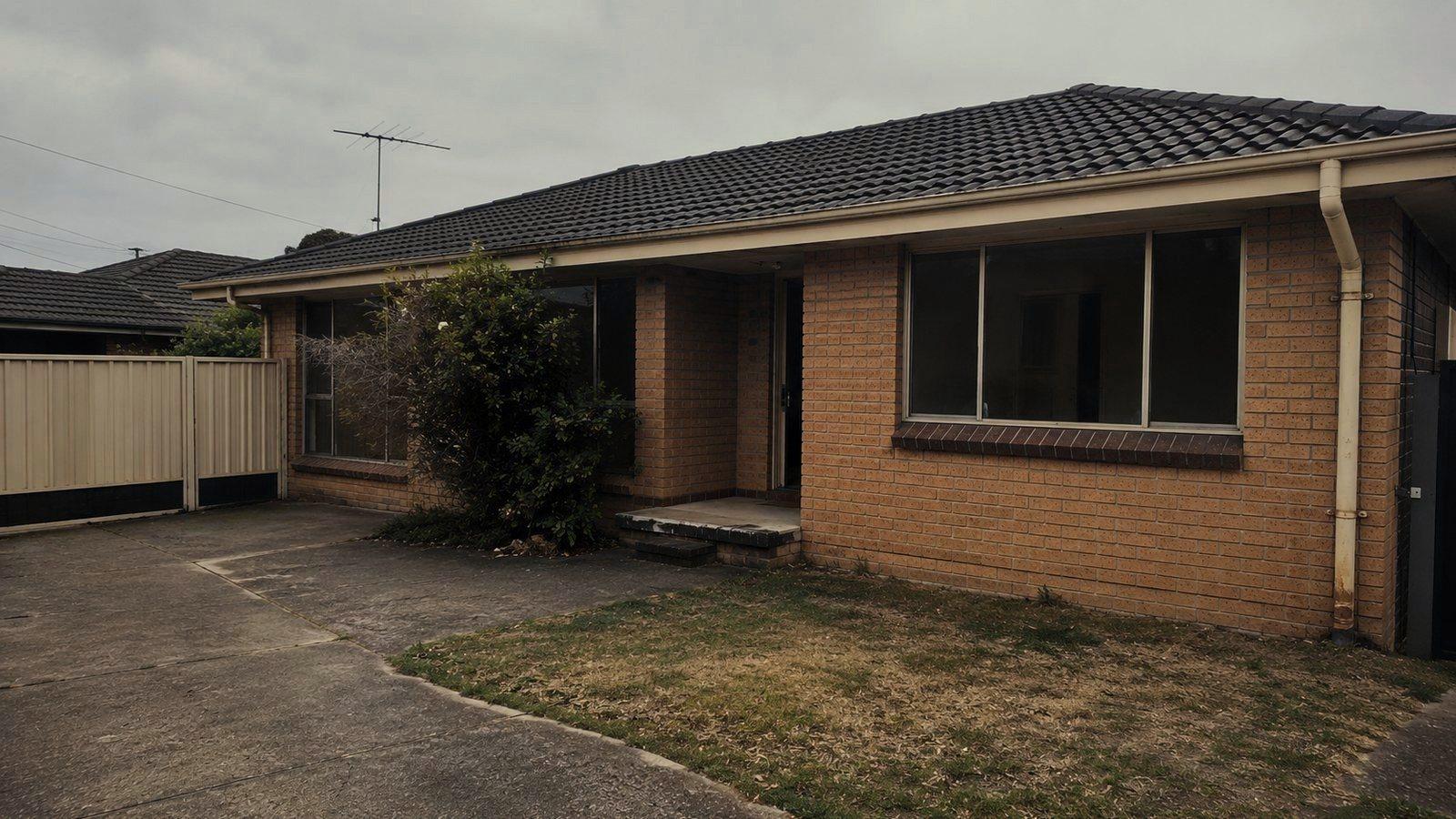 The front of an empty brick rental house between tenancies