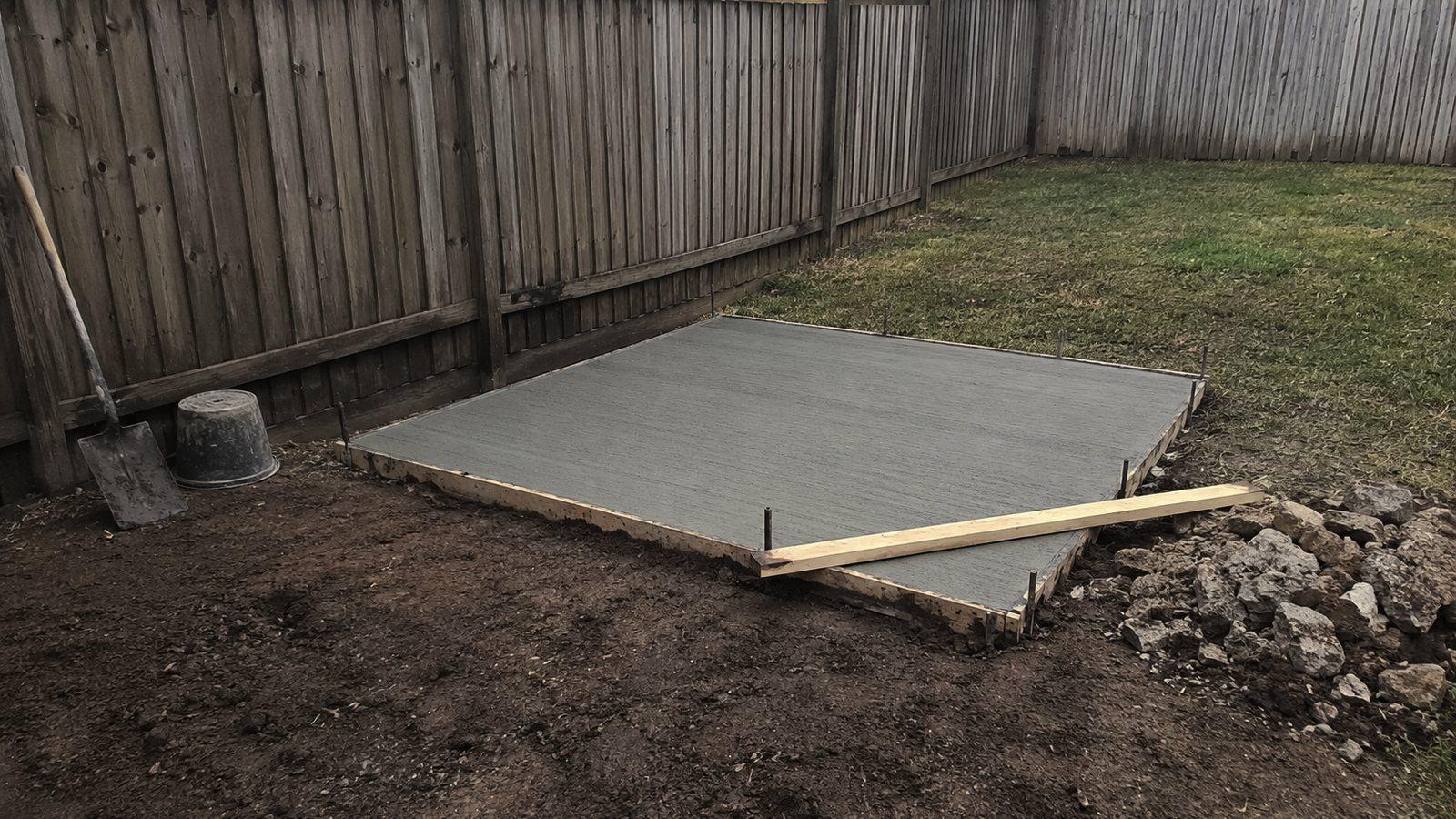 A small concrete path being screeded off between timber forms
