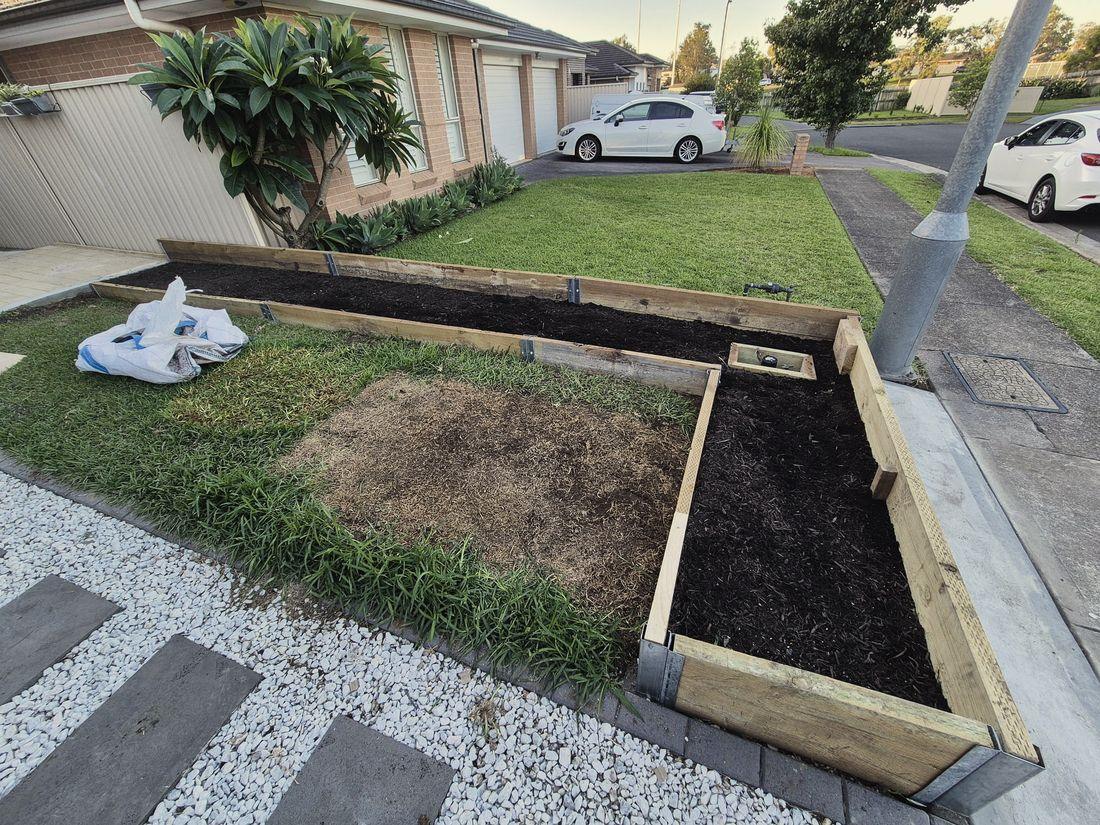 New treated pine garden beds built along a front lawn