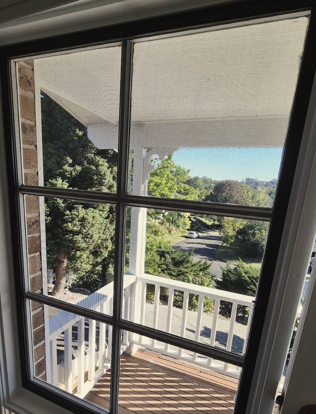 The same deck door with intact dark mesh covering the whole opening