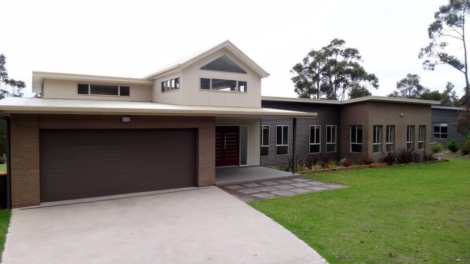 A rendered house exterior repainted, eaves and downpipes included