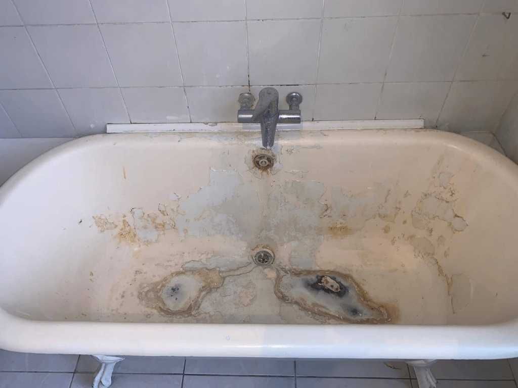 A stained and rusted cast iron bath