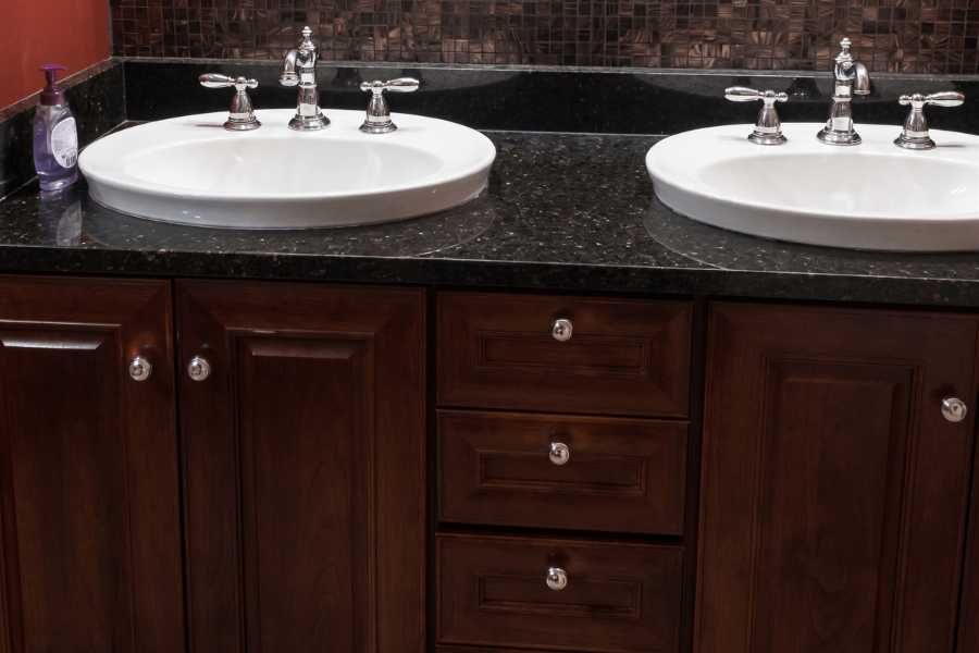 A dark timber double vanity with dated hardware